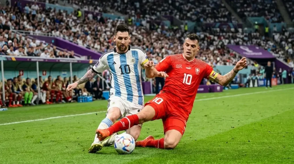 Messi_contesting_ball_with_Xhaka_202607110749 Messi enfrenta a marcação suíça em duelo entre Argentina e Suíça.