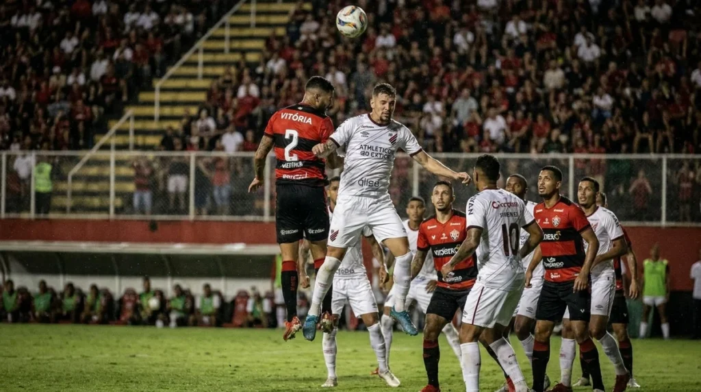 Jogadores de Vitória e Athletico-PR disputam bola em jogo da Copa do Brasil